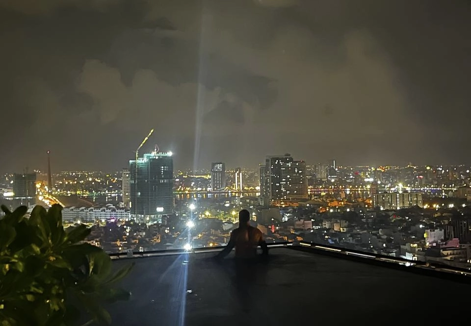 a city landscape view of Tyger in a rooftop pool overlooking the city center