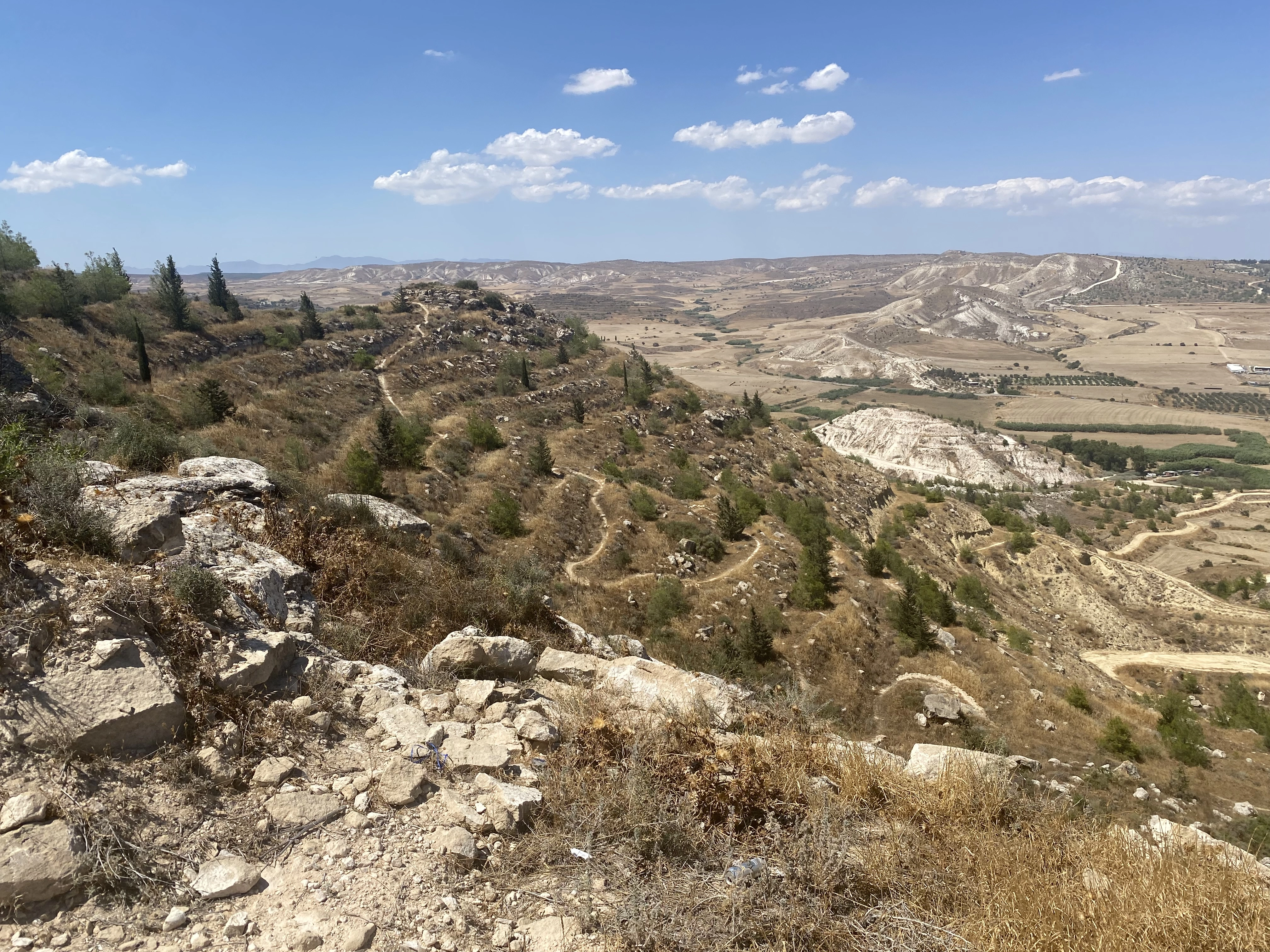 a landscape image of Cyprus mountains with blue sky and a snake road winding down the hill